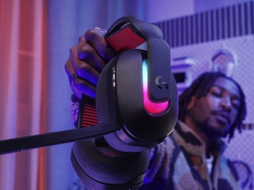 Un joven sujeta los auriculares Logitech G Astro A20 X Wireless