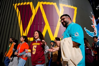 Aficionados de los Washington Commanders y de los Miami Dolphins posan para una fotografía fuera del estadio antes del partido.