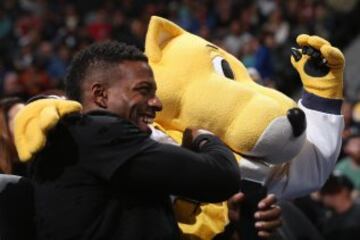 Emmanuel Sanders del equipo de la NFL Denver Broncos posa con Rocky, la mascota de los Nuggets.