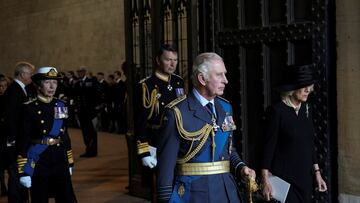 The king is putting on a hat previously worn by his mother, Queen Elizabeth III.