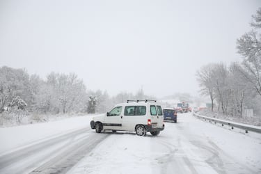 Varios vehículos se quedan parados mientras circulan con la nieve por la M-607.
