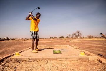 Un hombre juega al golf en el Club de Uagadugú (Burkina Faso), que cuenta con un campo de 18 hoyos y dos de nueve agujeros, todos certificados por la federación francesa. Aquí no hay greenes, sino 'marrones', y las calles se componen de tierra, piedras y arbustos nervudos en lugar de césped bien cuidado.