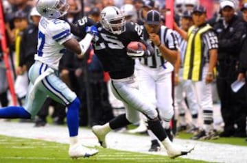 Charlie Gardner protege el balón de la embestida de Mario Edwards durante el American Bowl 2001.