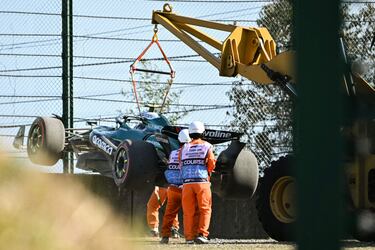 Los comisarios retiran el coche del piloto español Fernando Alonso después de quedarse atrapado en la grava en la segunda sesión de prácticas del Gran Premio de Japón de Fórmula Uno en el circuito de Suzuka en Suzuka.