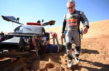 El piloto de Audi Carlos Sainz camina junto a su automóvil después de su accidente durante la Etapa 6 del Dakar 2023.