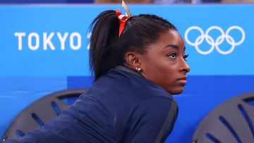 Simone Biles of the United States looks at the score board at the end of the beam competition.  