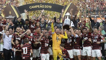 Players of Brazil's Flamengo celebrate on the podium with the trophy after winning the Copa Libertadores final football match by defeating Argentina's River Plate, at the Monumental stadium in Lima, on November 23, 2019. (Photo by Ernesto BENAVI