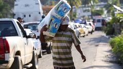 A man carries items he has taken from a supermarket that people had been broken into, in the aftermath of Hurricane Otis, near Acapulco, Mexico, October 26, 2023. REUTERS/Quetzalli Nicte-Ha