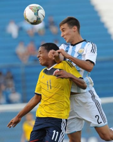 Jeison Lucumi  (izquierda) lucha un balón aéreo con Emanuel Mammana.