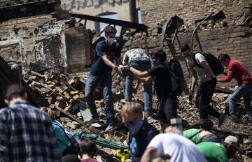 MINNEAPOLIS, MN - MAY 30: People work to clean up outside a burned building on May 30, 2020 in Minneapolis, Minnesota. Buildings and businesses around the Twin Cities have been looted and destroyed in the fallout after the death of George Floyd while in police custody. Police Officer Derek Chauvin has been charged with third-degree murder and manslaughter in Floyd's death. Stephen Maturen/Getty Images/AFP == FOR NEWSPAPERS, INTERNET, TELCOS & TELEVISION USE ONLY ==