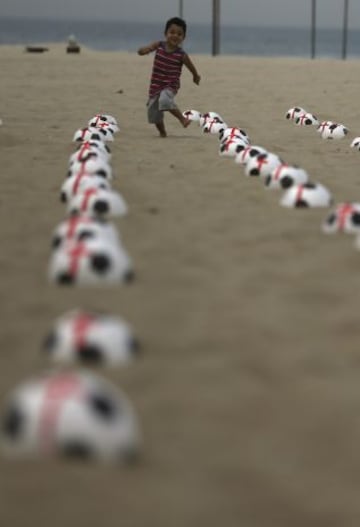 Miembros de la ONG Río de Paz colocan balones de fútbol marcados con cruces rojas como protesta en la playa de Copacabana en Río de Janeiro. La protesta fue un llamado al gobierno para que los servicios de educación, salud pública y para lograr los mismos estándares que los estadios de la Copa Mundial de la FIFA, de acuerdo con la Organización.