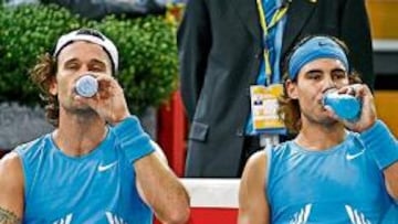 <b>VAYA PAR DE DOBLES. </b>Carlos Moyá y Rafa Nadal toman bebidas isotónicas en un descanso de su partido de dobles ante Blake y Fish.