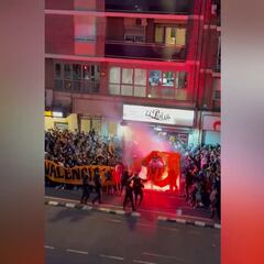 Un policía nacional apaga una bandera del Valencia que se había incendiado