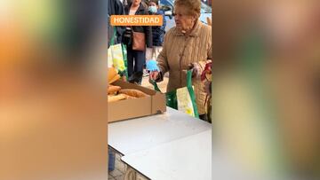 Una anciana en Benetúser queriendo pagar por el pan que se dona a los afectados por la DANA