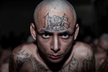 Un pandillero espera a ser llevado a su celda en el Centro de Confinamiento del Terrorismo, la nueva mega cárcel construida en El Salvador.