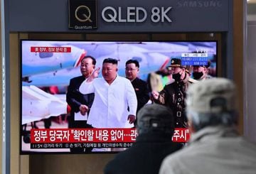 People watch a television news broadcast showing file footage of North Korean leader Kim Jong Un, at a railway station in Seoul on April 21, 2020. - South Korea played down a report on April 21 that the North's leader Kim Jong Un was being treated after s