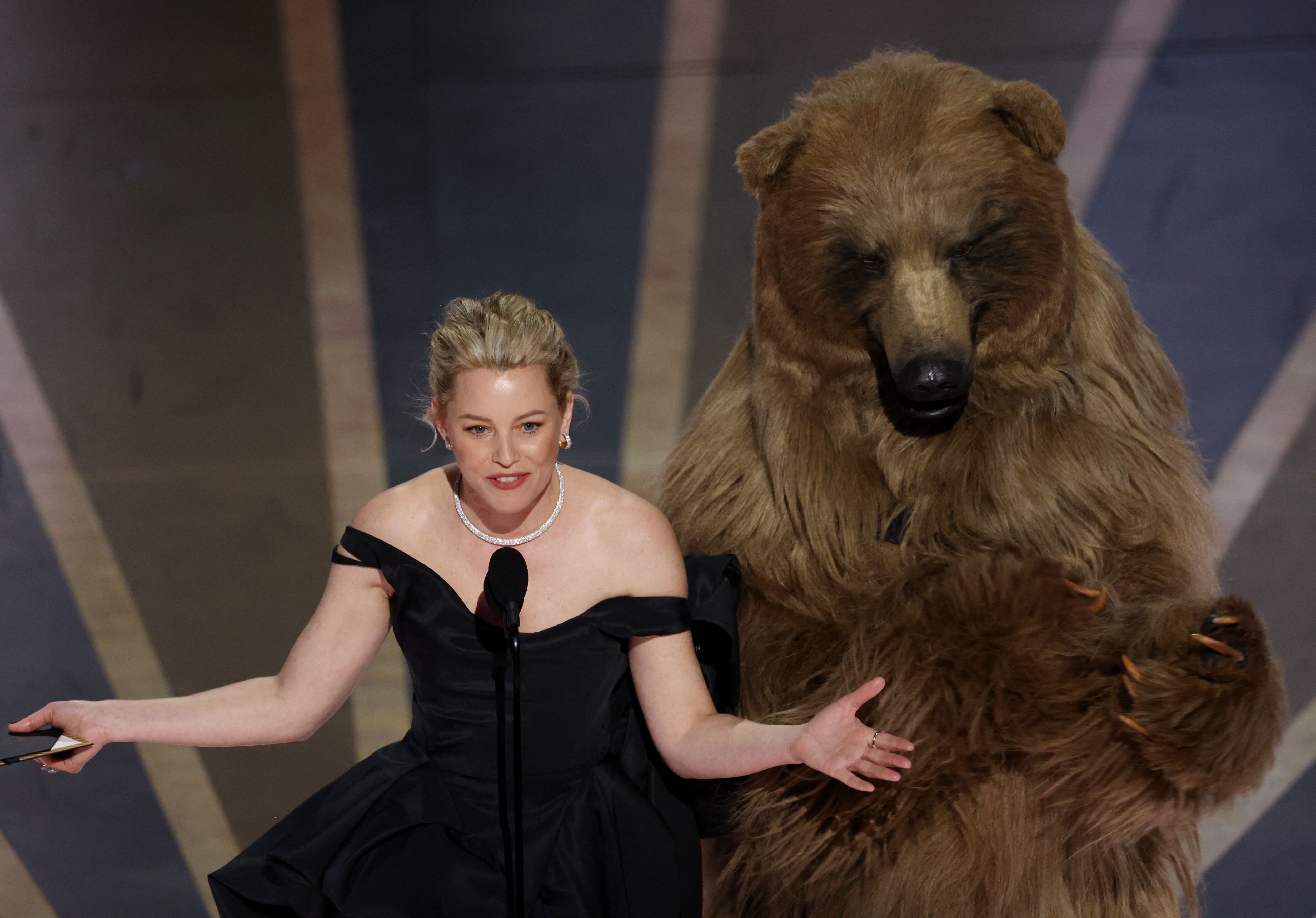 Elizabeth Banks is joined by an actor in a bear costume as she presents the award for Best Visual Effects during the Oscars show at the 95th Academy Awards in Hollywood, Los Angeles, California, U.S., March 12, 2023. REUTERS/Carlos Barria