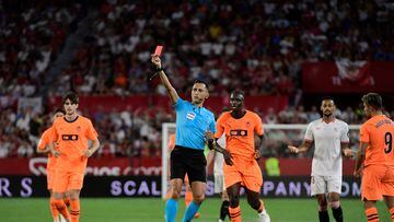 Spanish referee Jose Maria Sanchez Martinez shows a red card to Sevilla's French defender #22 Loic Bade (not seen) during the Spanish Liga football match between Sevilla FC and Valencia CF at the Ramon Sanchez Pizjuan stadium in Seville on August 11, 2023. (Photo by CRISTINA QUICLER / AFP)