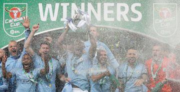 Manchester City's Belgian defender Vincent Kompany lifts the trophy as Manchester City players celebrate their victory in the English League Cup.