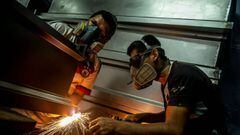 Workers weld a coffin at a factory at Juan de Lurigancho district in Lima, on June 3, 2020 amid the COVID-19 coronavirus pandemic. - While the Peruvian economy has been semi-paralyzed for 80 days due to the pandemic, coffin maker Genaro Cabrera has quadrupled his sales. (Photo by Ernesto BENAVIDES / AFP)