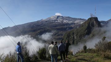 People watch steam and gases rising from the crater of the Nevado del Ruiz volcano, after the authorities declared an orange alert for the area and asked the nearby residents to evacuate as a preventive measure, as seen from Cerro Guali, Colombia April 19, 2023. REUTERS/Luisa Gonzalez