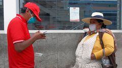 People in the highland city of Puno, close to the border with Bolivia, queue outside a bank on May 4, 2020 to collect the second bonus of 380 soles -about 107 US dollars- of governmental aid to help low income families to stay at home to fight the spread 