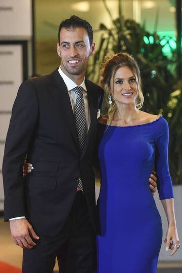 Barcelona's football player Sergio Busquets and his wife pose on a red carpet during Argentine football star Lionel Messi and Antonella Roccuzzo wedding in Rosario