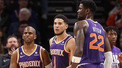 PHOENIX, ARIZONA - FEBRUARY 14: (L-R) Chris Paul #3, Devin Booker #1 and Deandre Ayton #22 of the Phoenix Suns react during the first half of the NBA game against the Sacramento Kings at Footprint Center on February 14, 2023 in Phoenix, Arizona. The Suns defeated the Kings 120-109. NOTE TO USER: User expressly acknowledges and agrees that, by downloading and or using this photograph, User is consenting to the terms and conditions of the Getty Images License Agreement.   Christian Petersen/Getty Images/AFP (Photo by Christian Petersen / GETTY IMAGES NORTH AMERICA / Getty Images via AFP)