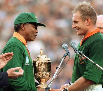 This iconic photo was taken on June 24, 1995 shows South African President Nelson Mandela congratulating South Africa's rugby team captain Francois Pienaar before handing him the Cup after the 1995 Rugby World Cup final between South Africa and New Zealan