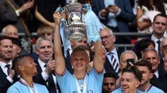 Manchester City's Norwegian striker Erling Haaland (C) lifts the trophy after the English FA Cup final football match between Manchester City and Manchester United at Wembley stadium, in London, on June 3, 2023. (Photo by Adrian DENNIS / AFP) / NOT FOR MARKETING OR ADVERTISING USE / RESTRICTED TO EDITORIAL USE