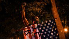 A demonstrator raises his fist as he holds an American flag during a protest against racial inequality in the aftermath of the death in Minneapolis police custody of George Floyd, in New York City, New York, U.S. June 9, 2020. Picture taken June 9, 2020. 