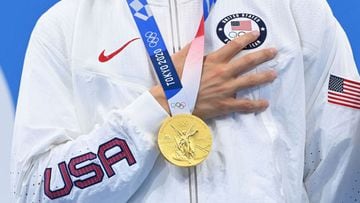A member of team USA places hand over heart under his gold medal for the US anthem on the podium after the final of the men&#039;s 4x100m medley relay swimming event during the Tokyo 2020.
