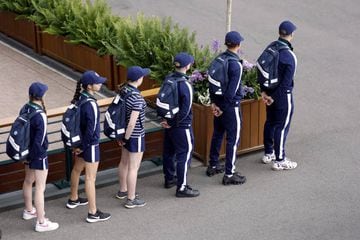 Ball boys and girls walk around the grounds in single file during day one of the 2022 Wimbledon Championships