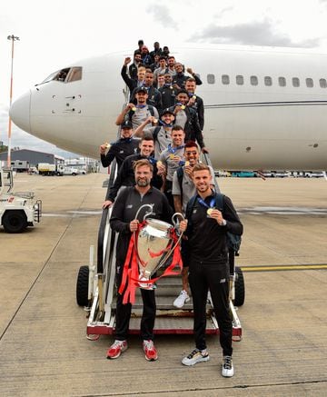 Jürgen Klopp, Jordan Henderson and the Liverpool squad pose with the Champions League trophy at John Lennon Airport.