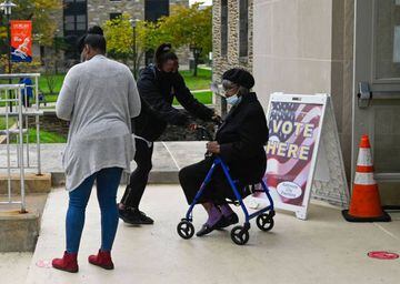 A woman is helped into an auditorium at Morgan State University, Baltimore, to vote.