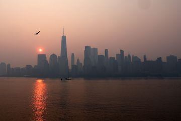 La torre One World Trade Center en el bajo Manhattan después del amanecer mientras la neblina y el humo causados por los incendios forestales en Canadá se ciernen sobre el horizonte.