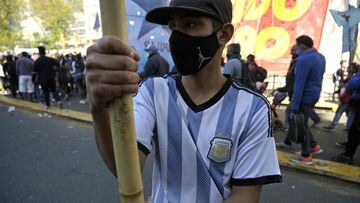 A youth wearing an Argentine jersey holds a bamboo pole holding a large flag during a demonstration called by social organizations to protest against the government of Argentina&#039;s President Alberto Fernandez, in Buenos Aires on September 21, 2021. - The demonstrators are demanding &quot;genuine jobs&quot;, basic salaries of $70,000 (some 675 US dollars) and the resignation of the antiabortion Argentine chief cabinet Juan Manzur. Fernandez reshuffled his cabinet to smother a political crisis that pitted him bitterly against his vice president this week after an electoral defeat in legislative primaries. (Photo by Juan MABROMATA / AFP)
