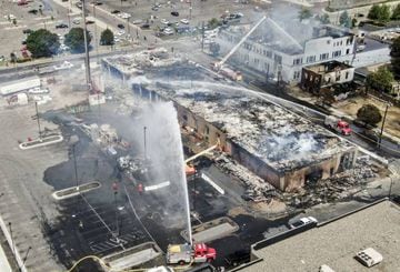 An aerial photo made with a drone shows firefighters battling fires set near the Minneapolis police 3rd Precinct, during a third day of protests over the arrest of George Floyd.