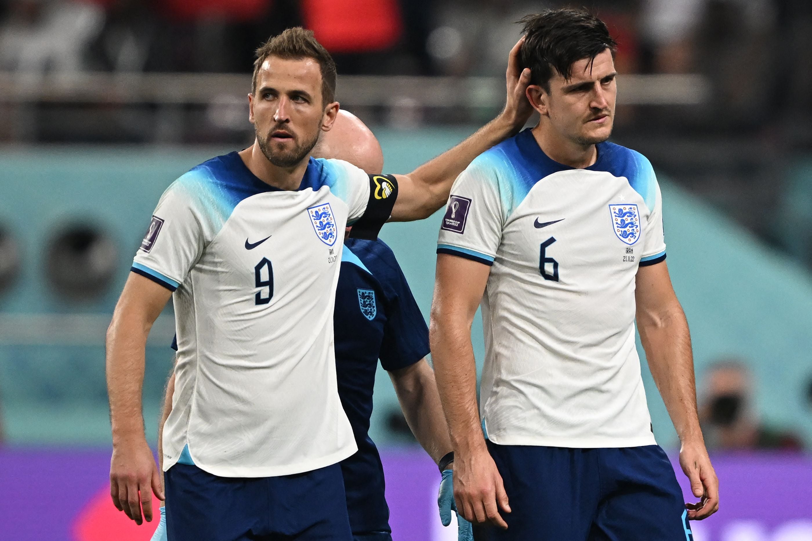 England's forward #09 Harry Kane (L) gestures to his teammate defender #06 Harry Maguire during the Qatar 2022 World Cup Group B football match between England and Iran at the Khalifa International Stadium in Doha on November 21, 2022. (Photo by Paul ELLIS / AFP)