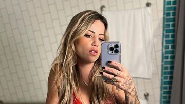 La skater Leticia Bufoni se hace un selfie en el espejo con su iPhone y un ba&ntilde;ador rojo, mostrando sus tatuajes. En el lavabo. 