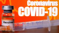 FILE PHOTO: A small bottle labeled with a &quot;Vaccine&quot; sticker stands near a medical syringe in front of displayed &quot;Coronavirus COVID-19&quot; words in this illustration taken April 10, 2020. REUTERS/Dado Ruvic/Illustration/File Photo