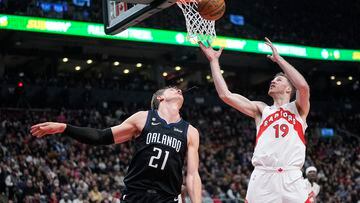 Feb 14, 2023; Toronto, Ontario, CAN; Toronto Raptors center Jakob Poeltl (19) goes after a rebound against Orlando Magic center Moritz Wagner (21) during the first half at Scotiabank Arena. Mandatory Credit: John E. Sokolowski-USA TODAY Sports