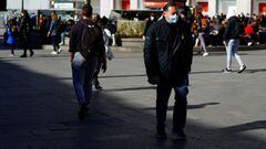 A man wearing a protective face mask walks down a street in Madrid, Spain, February 7, 2022. REUTERS/Borja Suarez