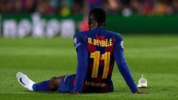 Barcelona forward Ousmane Dembele sits on the ground after an injury