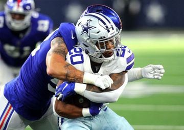 ARLINGTON, TEXAS - OCTOBER 10: Tony Pollard #20 of the Dallas Cowboys is tackled by Carter Coughlin #52 of the New York Giants during the fourth quarter at AT&T Stadium on October 10, 2021 in Arlington, Texas.