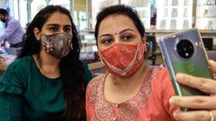 Customers wearing handmade facemasks studded with diamonds take selfie pictures at D Khushalbhai Jewellers showroom in Surat, some 270 km from Ahmedabad on July 25, 2020. (Photo by STR / AFP)
