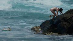 Una surfista escala por las rocas para salir del agua en Honolulu, Haw&aacute;i, el 25 de junio del 2023, tras estamparse contra las mismas por culpa de las corrientes y las olas. 
