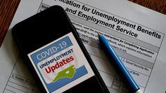 Logotipo de Actualizaciones de asistencia por desempleo de COVID-19 en un tel&eacute;fono encima de una solicitud de beneficios por desempleo el 8 de mayo de 2020, en Arlington, Virginia.
