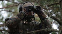 PABRADE, LITHUANIA - OCTOBER 27: An infantry soldier of the Bundeswehr, the German armed forces, looks through binoculars during the NATO Iron Wolf military exercises on October 27, 2022 in Pabrade, Lithuania. Germany leads a NATO contingent of troops in Lithuania under the Enhanced Forward Presence  (eFP) battle group, with troops also from Belgium, the Czech Republic, the Netherlands, Luxembourg and Norway.   (Photo by Sean Gallup/Getty Images)