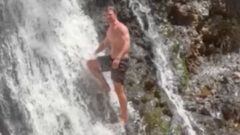 El actor australiano Chris Hemsworth, en ba&ntilde;ador, en una cascada, a punto de practicar cliff diving. 